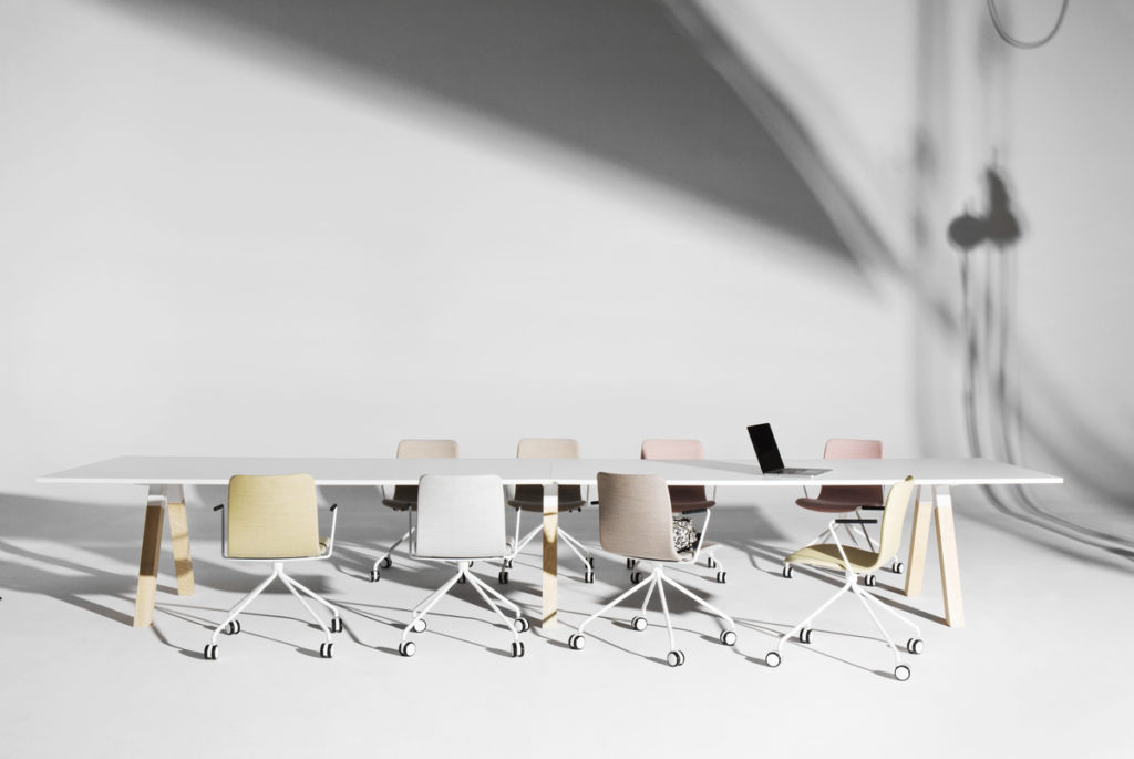 vitt rum med stort bord och kontorsstolar