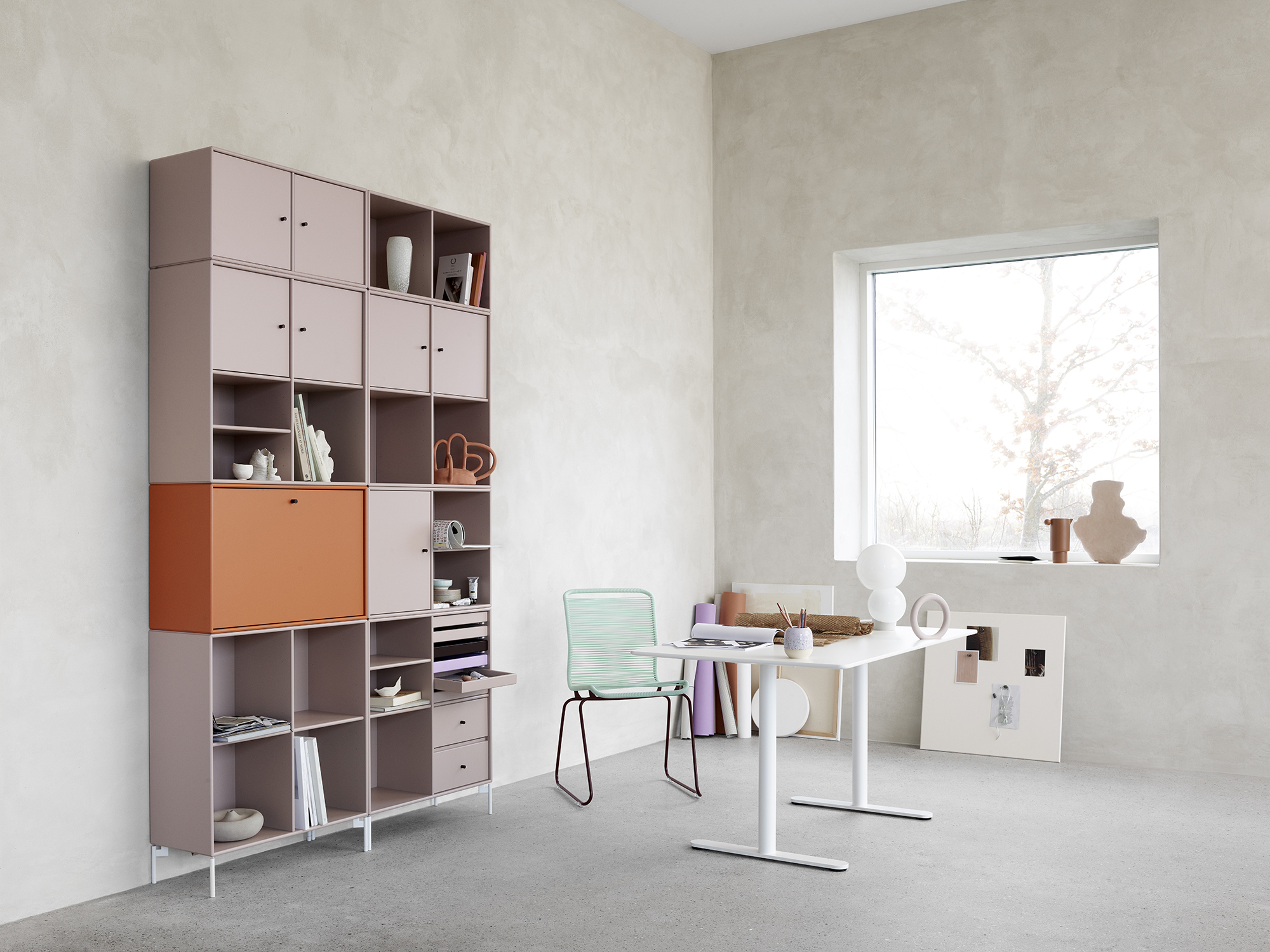 Hylla i färgerna rosa och range samt vitt skrivbord med turkos stol