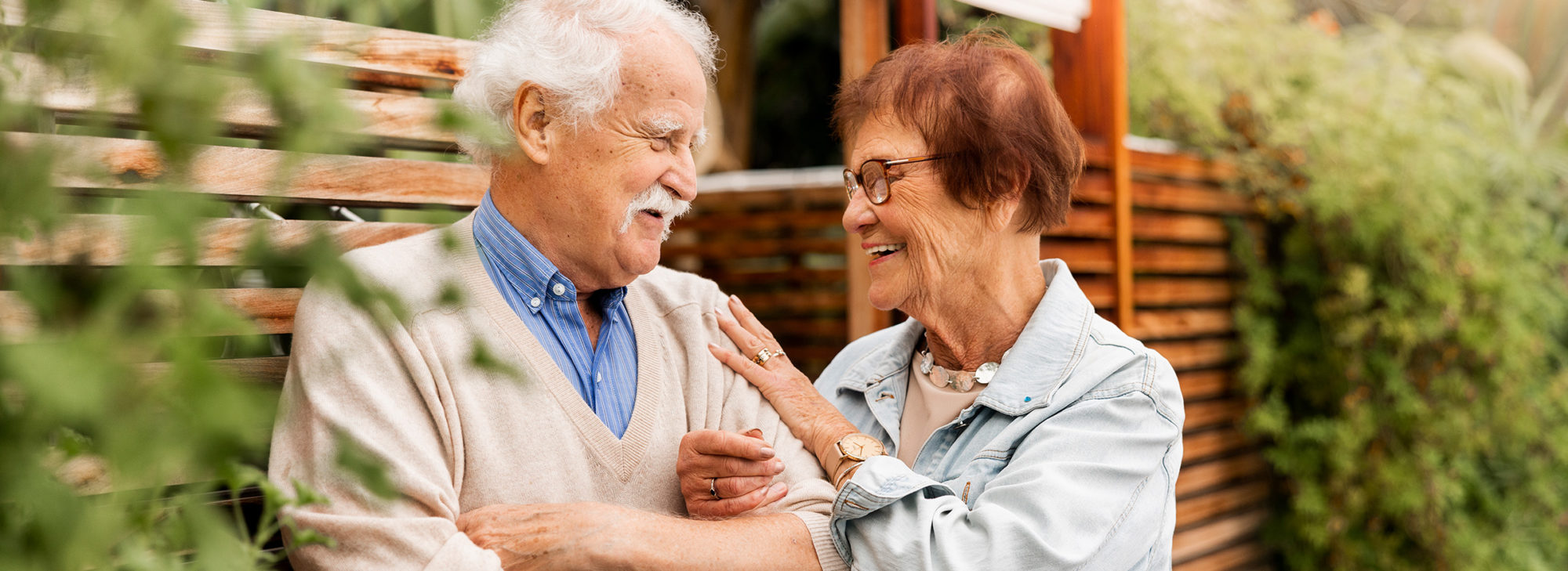 Äldre par som håller armkrok utomhus och skrattar