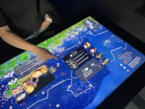 En person som pekar på en skärm som visar sverige och havet