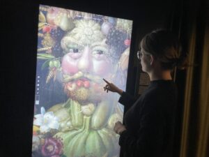 Skärm med konstverk av man gjort av frukt och grönsaker