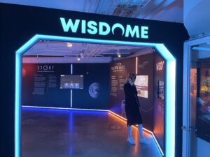 Ingången till Wisdome med en tjej som lyssnar på något i en av utställningarna