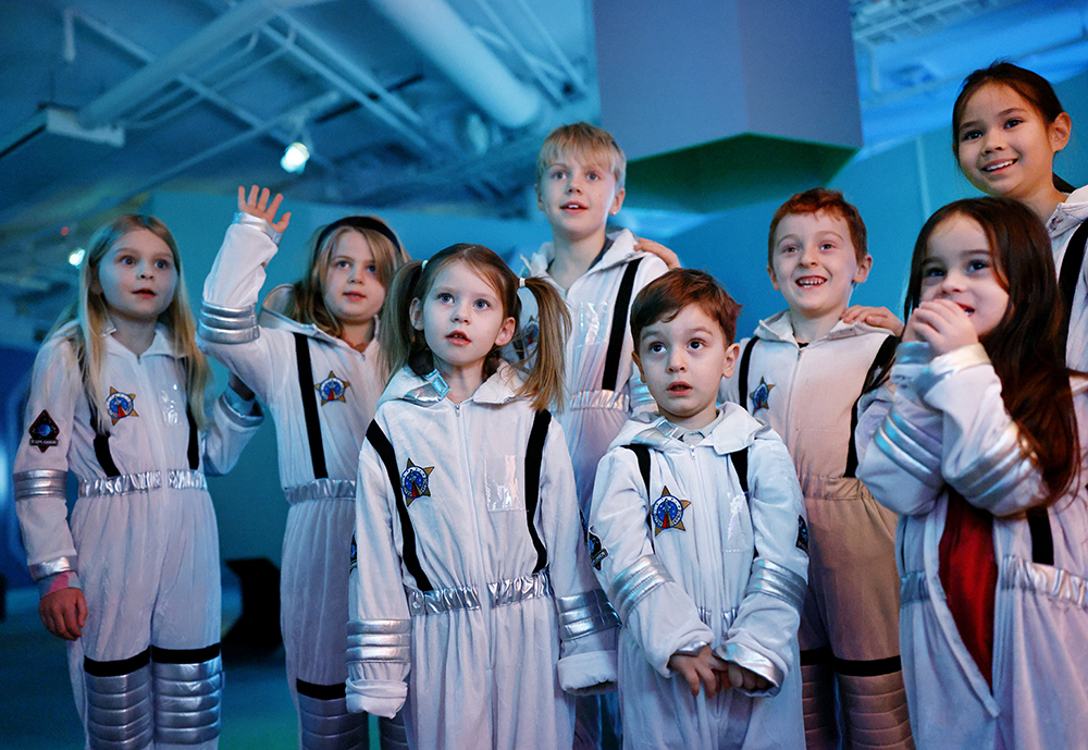 Ett gäng kalasbarn i rymddräkter är samlande.