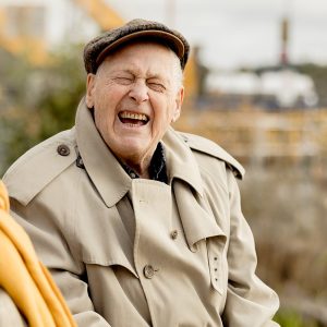 Äldre par som sitter på brygga ute och skrattar