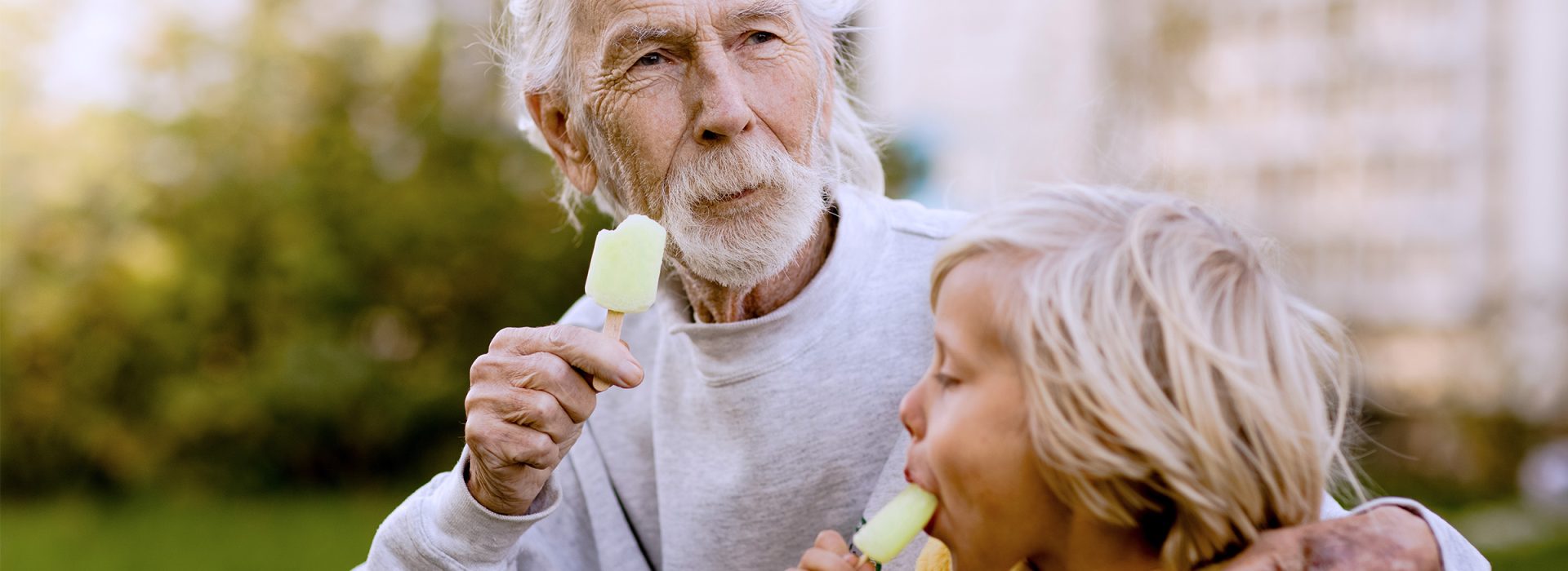 Äldre man som äter glas tillsammans med liten pojke