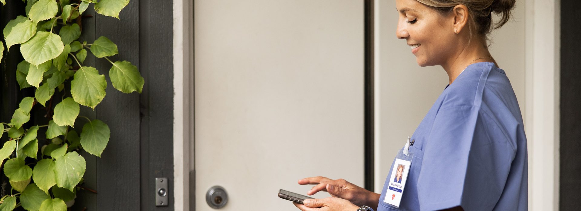 Personal med telefon som öppnar en dörr